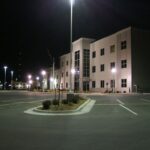 Outside image at night of a building and parking lot with exterior security lighting