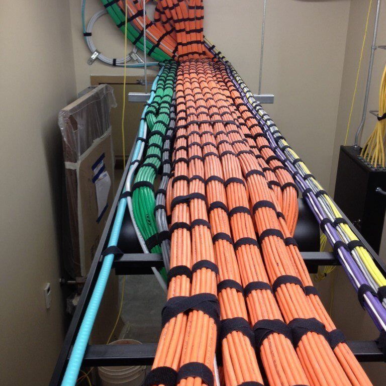 orange, green and other colors of cables running through wall